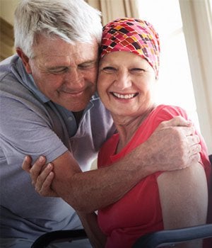 Smiling cancer patient being hugged by a relative. Chronic medical conditions.